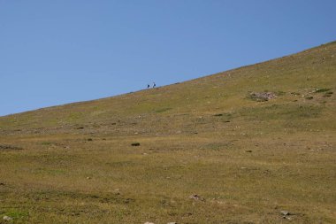 İki dağcı dağın yamacında yürüyorlar.