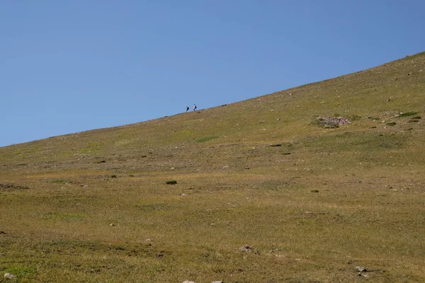 İki dağcı dağın yamacında yürüyorlar.