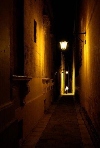 A lantern illuminates a part of the night street in the old town. High quality photo