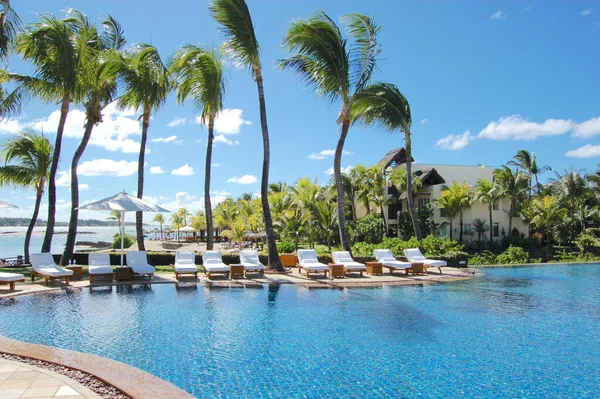 Okyanusta güneşli havuz ve güneş şemsiyeleri.