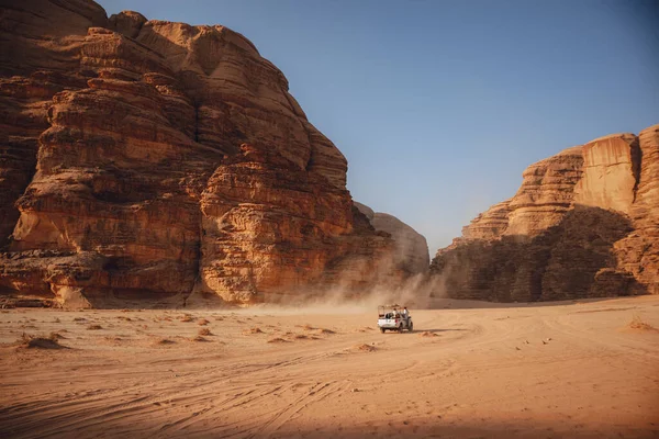 요르단의 바위투성이의 산들이 모래가 지대를 자동차로 운전하는 것이다 모래를 폭풍을 스톡 이미지