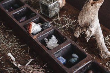 A collection of various different crystals on a messy wiccan witch's altar. Crystal magick