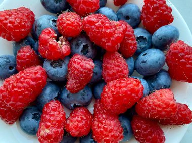 Taze taze yaban mersini ve ahududu karışımı, organik sağlıklı yiyecekler, lezzetli renkli böğürtlenler..