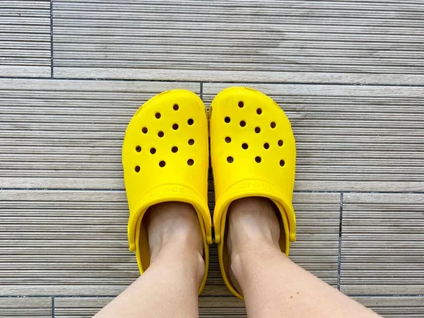 Legs Bright Yellow Crocs Footwear Grey Background Copy Space Text — Stock Photo, Image
