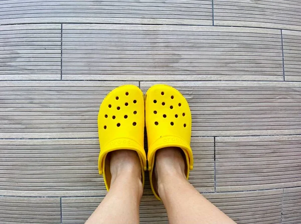 Legs Bright Yellow Crocs Footwear Grey Background Copy Space Text — Stock Photo, Image