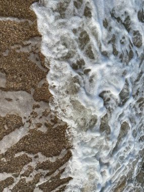 waves breaking into the water of the sea in summer