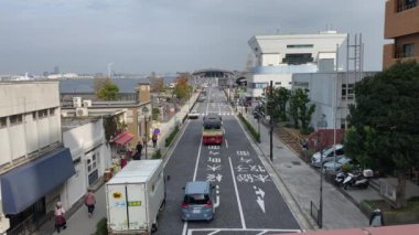 Yokohama uluslararası yolcu terminalinin girişi ve yolda güzel kırmızı bir otobüs görünüyor.