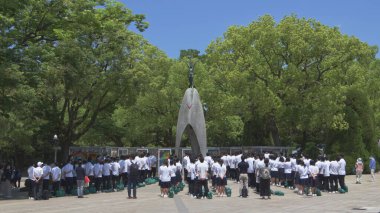 Çocuklar Barış Anıtı önünde sessizce dua eden öğrenciler