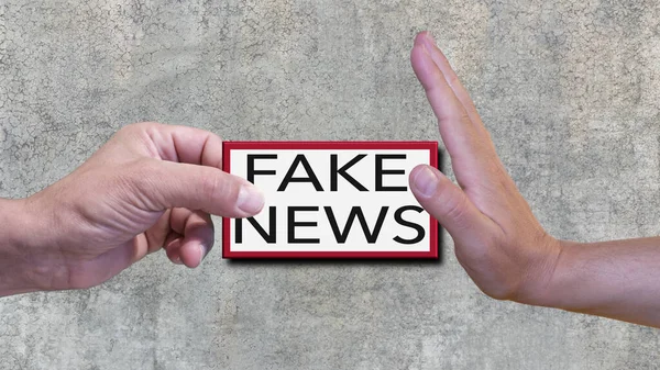 One hand does not accept fake news. In the background a concrete wall. Conceptual photo