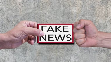 One hand does not accept fake news. In the background a concrete wall. Conceptual photo