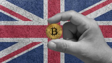 Bir elinde Bitcoin, btc, geleceğin kripto para birimi. Arka planda yıkılmış beton duvardaki İngiliz bayrağı.