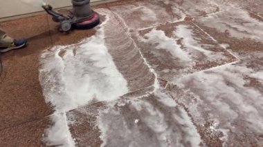 Profesyonel bir zemin temizleyicisiyle kırmızı granit zemini yıkamak ve profesyonel bir elektrikli süpürgeyle siyah suyu temizlemek.