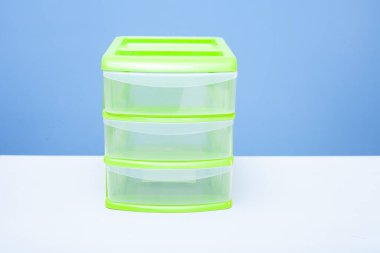 Üç şeffaf çekmeceli yeşil plastik konteynır. ön görünüm