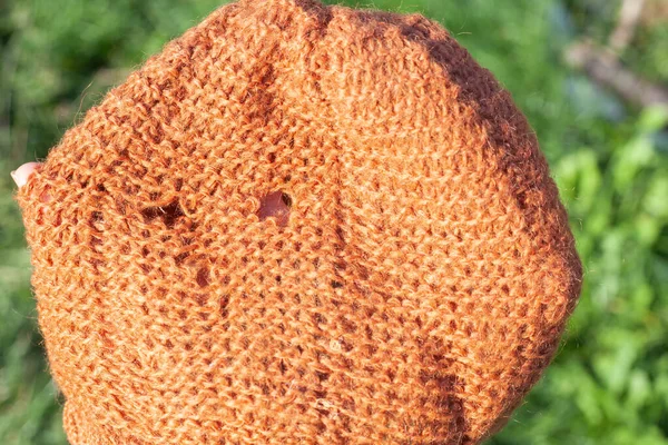 Kilka dziur na damskiej dzianinie pomarańczowy kapelusz — Zdjęcie stockowe