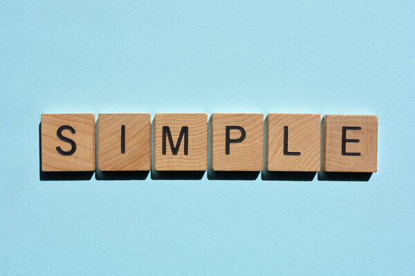 Simple, word in wooden alphabet letters isolated on plain blue background