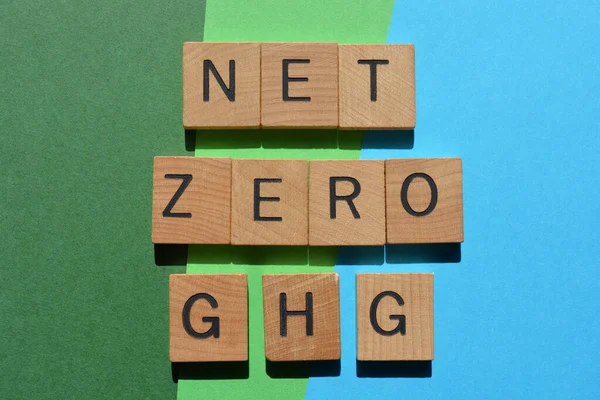 Net Zero GHG, words in wooden alphabet letters isolated on blue and green background