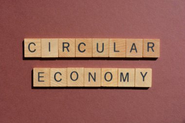 Yuvarlak Ekonomi, kahverengi arka planda izole edilmiş ahşap alfabe harfleriyle kelimeler.