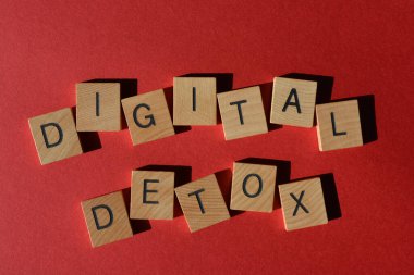 Digital Detox, words in wooden alphabet letters isolated on bright red background