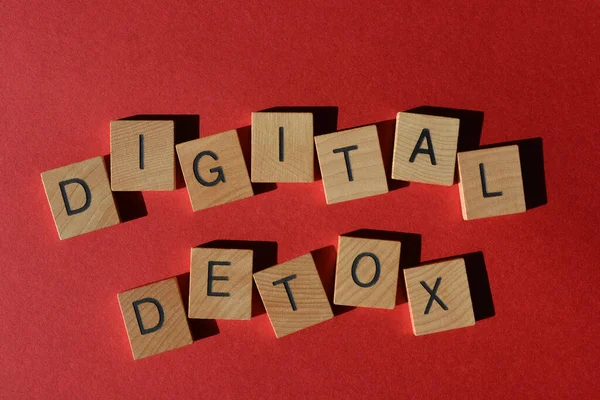 Dijital Detox, parlak kırmızı arkaplanda izole edilmiş tahta alfabe harflerindeki kelimeler