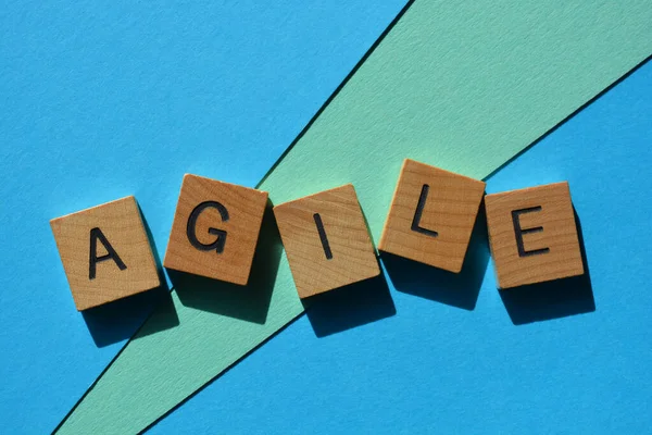 Çevik, ahşap alfabe harfleri ile kelime mavi arka planda izole