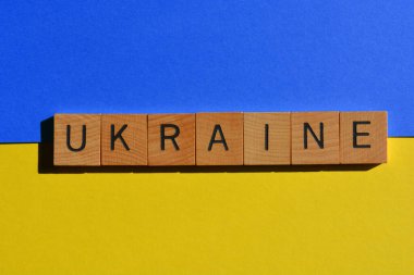 Ukrayna, kelime ahşap alfabe harfleriyle mavi ve sarı arka planda izole edilmiş.