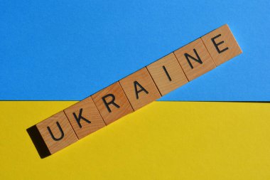 Ukrayna, ahşap alfabe harflerindeki kelime mavi ve sarı arka planda izole edilmiş, ulusal bayrak renkleri