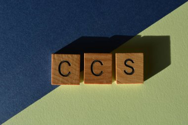 CCS, karbon yakalama deposunun kısaltması, mavi ve yeşil arkaplanda izole edilmiş ahşap alfabe harfleri.