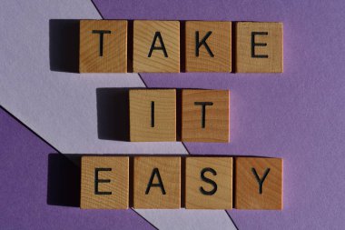 Sakin ol, ahşap alfabe harfleriyle yazılmış kelimeler mor arka planda izole edilmiş.