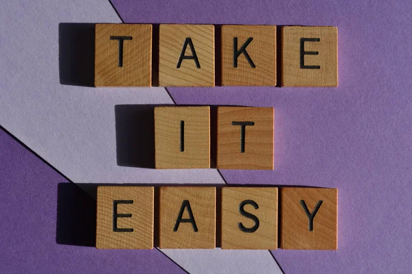 Sakin ol, ahşap alfabe harfleriyle yazılmış kelimeler mor arka planda izole edilmiş.