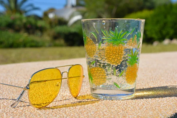Óculos Sol Amarelos Lado Uma Bebida Fria Límpida Carbonatada Livre — Fotografia de Stock