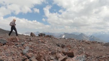 Bir turist yüksek dağlarda yürür. Beyaz kadın.