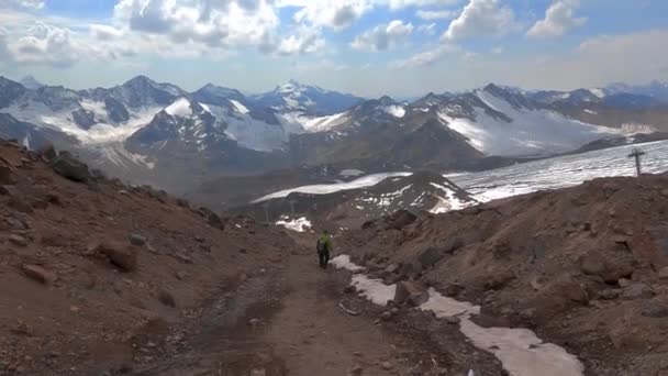 Een toerist daalt een steile stenen weg af vanaf de berg Elbrus. — Stockvideo