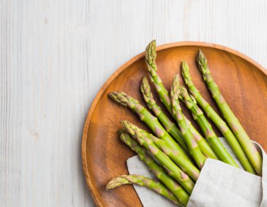 Keten peçeteye sarılmış bir buket taze kuşkonmaz..