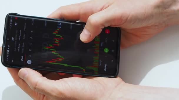 Investor kontroluje dynamiku hodnoty akcií na obrazovce chytrého telefonu. — Stock video