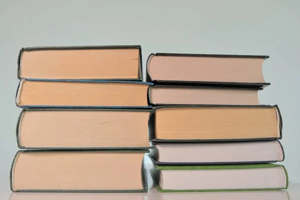 Welttag des Buches. Lesen und Bildung. Zwei Stapel Bücher auf hellem Hintergrund. Bücher in Nahaufnahme. — Stockfoto