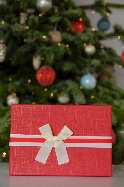 Christmas Surprises and gifts for the winter holidays. Red boxes on Christmas tree background.Christmas and New Years holiday.Merry Christmas.