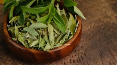 Stevia Rebaudiana ahşap bir masada yuvarlak bir bardakta. Organik düşük kalori tatlandırıcı.