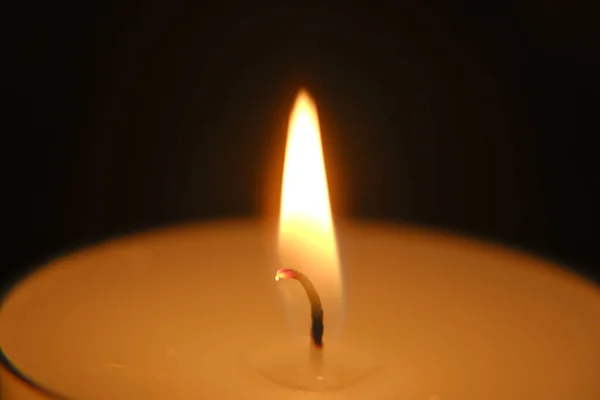 Vela sobre fondo negro.. Vela flame.Candle fondo. Vela ardiente en la oscuridad. Vela de primer plano llama. — Foto de Stock
