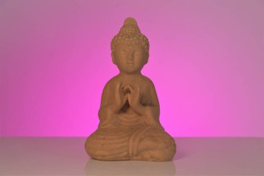 Pembe arka planda Buda. Budizm sembolü. Meditasyon ve rahatlama. Budizm dini geçmişi..