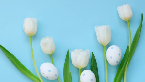 Sfondo pasquale. Uova di Pasqua e fiori. Tulipani bianchi e uova bianche in un granello blu su uno sfondo azzurro.Festa religiosa primaverile — Video Stock