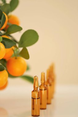 C vitamini serumu. C vitamini ampulleri ve mandalina meyvesi. Ampuller ve C vitamini ve güzellik. Organik doğal kozmetik.