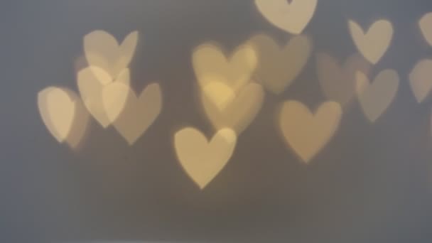 Liefdesconcept. Valentijnsdag. Gloeiende bokeh harten. Liefdessymbool. romantische achtergrond in grijze en gele tinten — Stockvideo