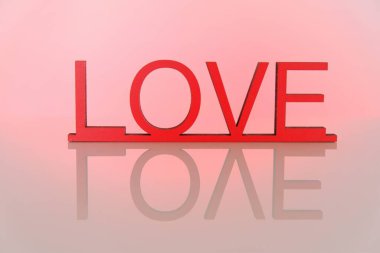 Aşk konsepti. Sevgililer Günü. Pembe bir arkaplanda yazı aşkı. Aşk sembolü. Pembe renklerde şenlikli romantik bir geçmiş. Aşk ve ilişki sembolü..