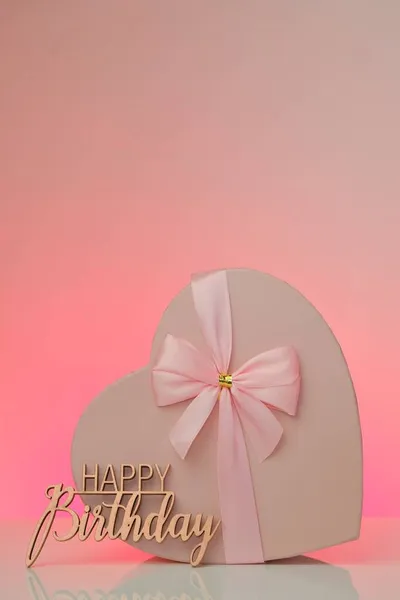 Gelukkige verjaardag.Roze hart doos en inscriptie Gelukkige verjaardag op een roze achtergrond.Feestelijke achtergrond — Stockfoto