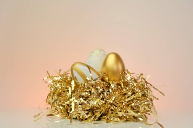 Paskalya tatili arka planında. Altın teneke bir yuvada altın Paskalya yumurtaları. Tatil arkaplanı. Bahar dini bayramı