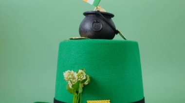 Aziz Patrick şenlik arka planı. Yeşil leprikon şapkalı siyah melon şapka ve açık yeşil arka planda altın sikkeli yoncalar.