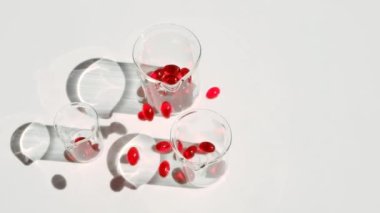 Beyaz arka planda kril yağı jelatin kapsülleri. Uçan kapsüller kırmızı kril yağı. Omega yağ asitleri. Doğal takviyeler ve vitamin.