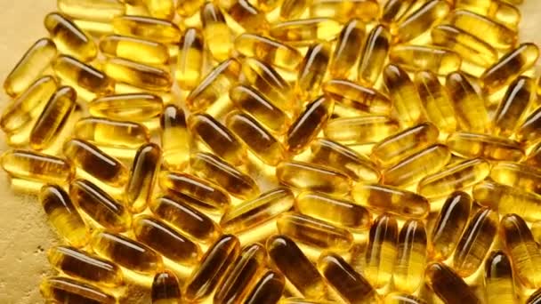 Fish Oil Cápsulas fundo de ouro. Suplementos naturais e vitaminas. ácidos gordos ómega. Cápsulas de óleo de peixe fundo. — Vídeo de Stock