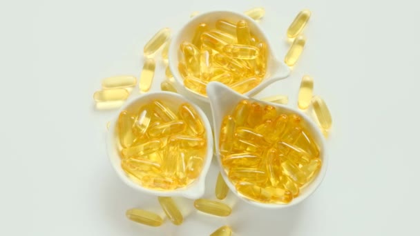 Cápsulas de aceite de pescado en vasos de cerámica. Rotation.omega ácidos grasos — Vídeos de Stock