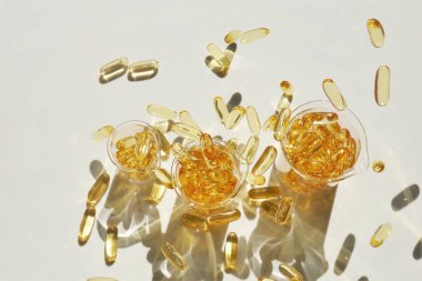 Omega yağ asitleri. Beyaz arka planda şeffaf şişelerde balık yağı kapsülleri. Doğal takviyeler ve vitaminler..